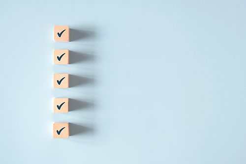 fünf Würfel übereinander, mit einem Häkchen darauf